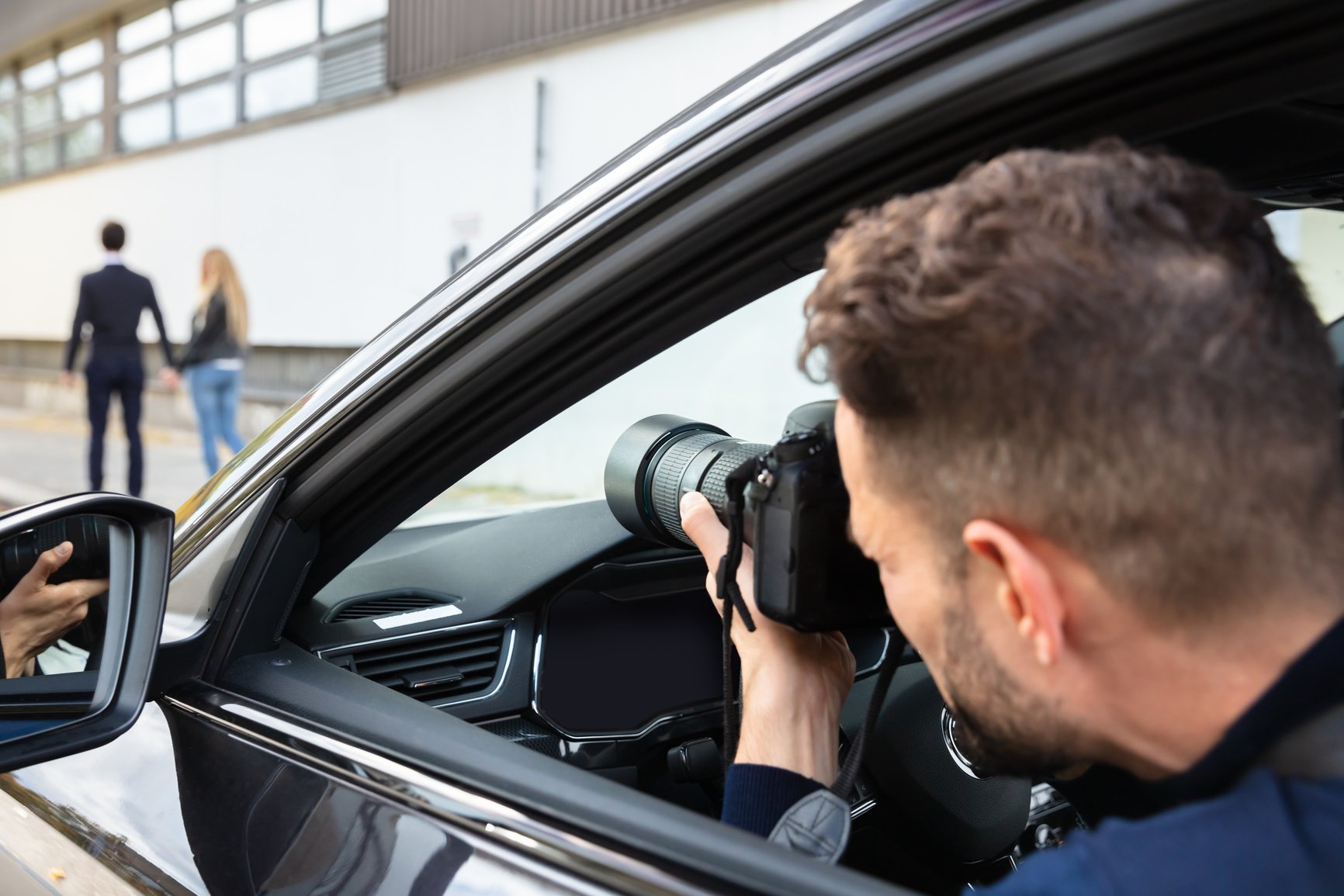 Private Detective Taking Photos Of Man And Woman